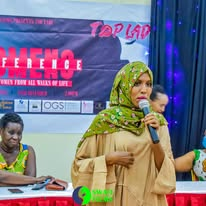 A speaker in a green headscarf at a Top Lady event